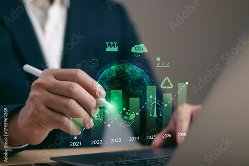 Photos Closeup of businessman using digital pen on a timeline bar chart showing sustainable growth and eco goals from 2021 to 2050