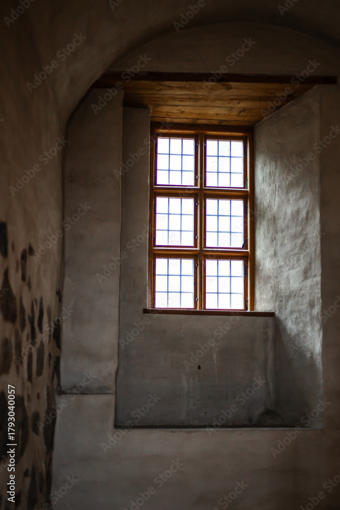 Obraz premium Old castle interior with antique furniture, stone walls, and warm light creating a medieval atmosphere full of history and mystery.