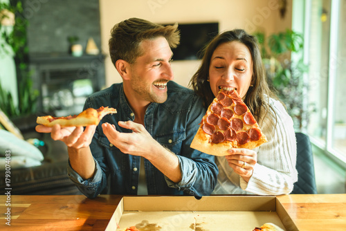 Wallpaper Mural Loving couple shares tender moment in modern kitchen, enjoying pizza Torontodigital.ca