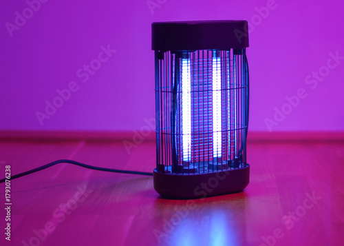 Electric insect killer lamp glowing in purple light