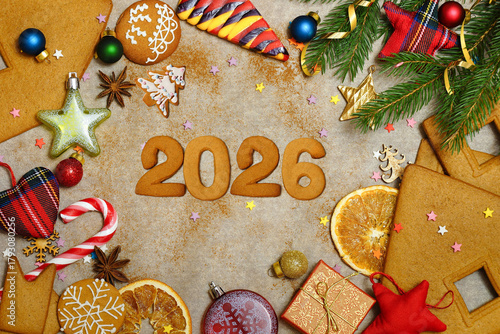 New Year's greetings for 2026 with homemade cookies. Gingerbread cookies, Christmas decorations and decorations on paper. View from above