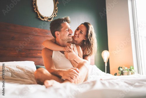couple sharing tender on a cozy blanket in bed, enjoying love and affection