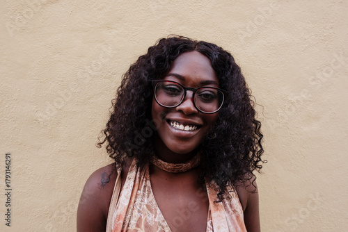 Black woman smiling, wearing glasses and showing joy