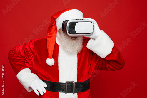 Profile side view portrait of his he bearded fat overweight Santa wear vr helmet gadget device equipment enjoying watching realistic experience air blow wind isolated red color background
