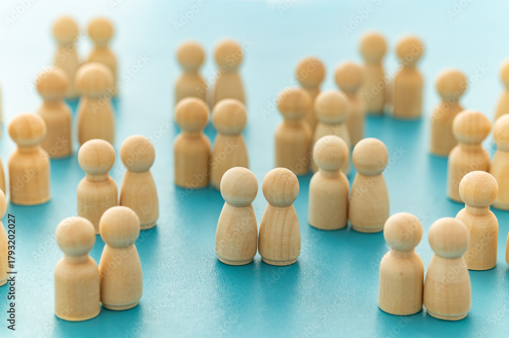 Obraz premium Two identical wooden figures among heterosexual pairs, symbolizing equality, diversity, and inclusion.