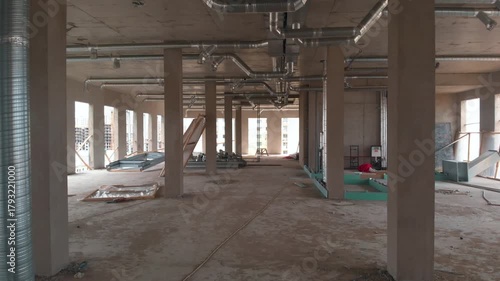 The interior of a building under construction. The camera is moving inside the building. Construction site.
