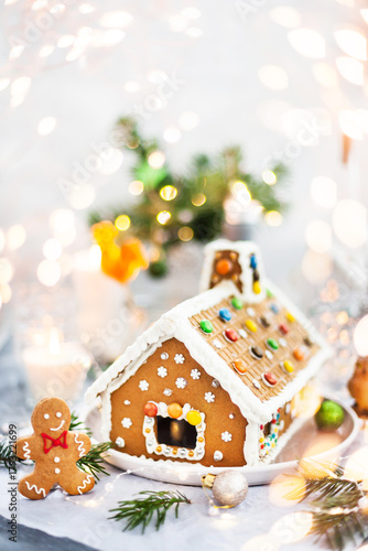 Homemade Christmas gingerbread house with holiday   decorations, candles and lanterns on  background