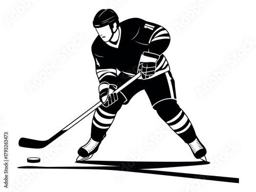 A hockey player wearing a uniform and skates is about to hit the puck with a stick.
