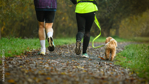 Man and woman running with dog