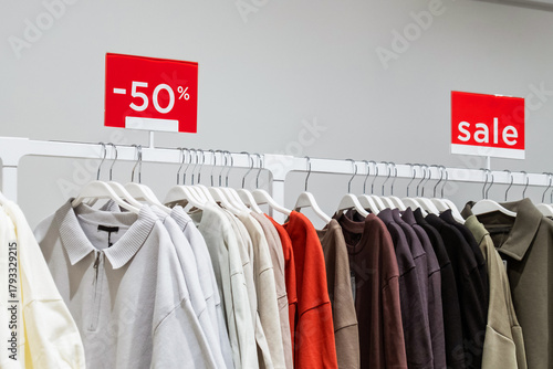 Clothing rack showcasing a variety of shirts with a 50 percent discount sign highlighted. The bright red sale signs emphasize the Black Friday shopping event, drawing customers in