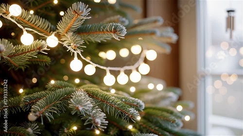 Warm light on a fir tree: hands hanging a ball garland at a winter window, cozy macro shot
