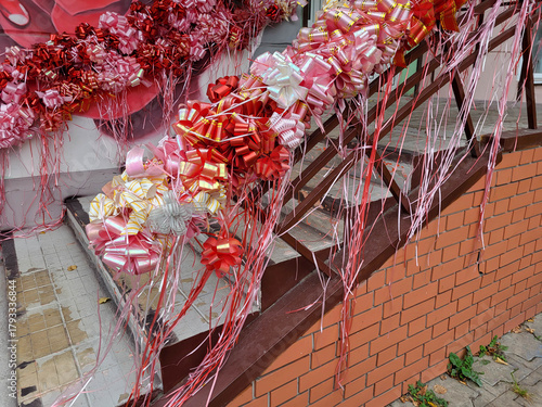 On a clear day, a staircase decorated with ribbons and bows. An idea for decorating the interior for Family Day, March 8, and Valentine's Day