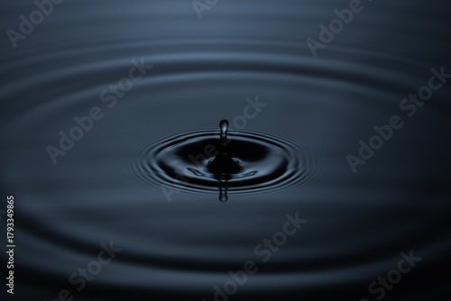 Slika na platnu Black liquid drop resembling crude oil falling, macro splash on a natural backgr