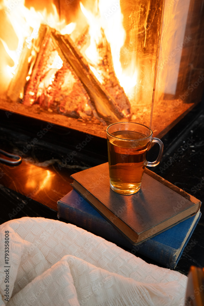 Naklejka premium Imagine a cozy scene with beloved books, soothing tea, and a crackling fireplace for ultimate relaxation