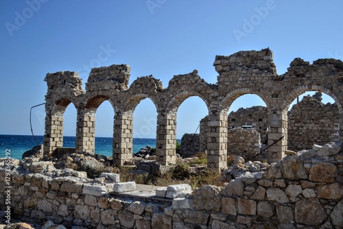 Ruins of an old industrial building made of stone, located by the Aegean Sea in Samos, Greece. Historical coastal architecture and abandoned structure concept.