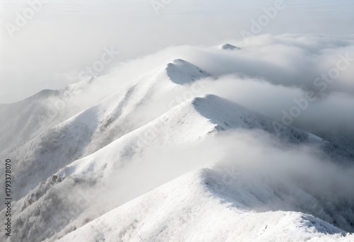 A breathtaking view of snow-covered mountain peaks gently rising from a sea of clouds, creating a serene and tranquil landscape.