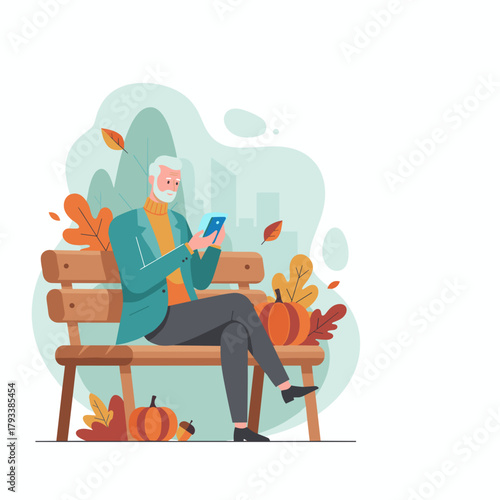 Stylish senior man uses mobile phone on a park bench during the autumn season