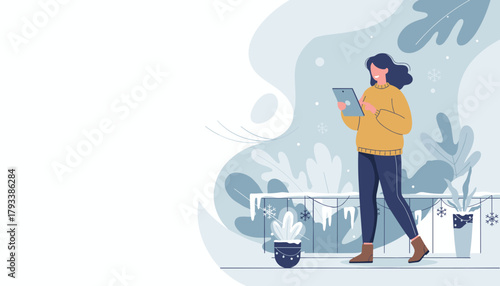 Happy woman in warm sweater using a digital tablet outside during winter snowfall