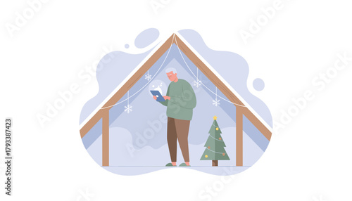 Senior man uses tablet in a festive snowcovered attic with Christmas tree