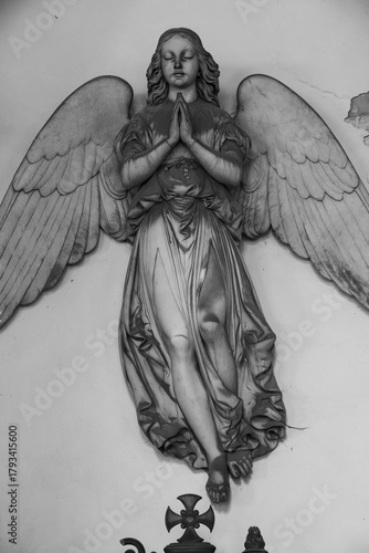 Ancient statue of angel in Italian old cemetery. Religious sculpture, no people, grey marble