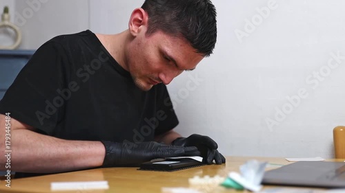 A man cleans the back of a smartphone from dust with a napkin after repair.