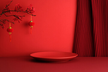 Round display podium plate , plum blossom branch, and hanging red lantern on red background with curtain. Chinese New Year, Lunar New Year concept.