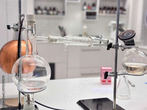 Fotografia laboratory setup with glass round bottom flask connected to a condenser coil on