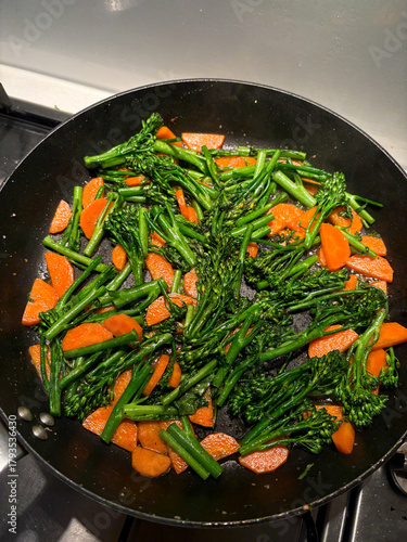 Stir fry of broccolini and carrot on the frying pan.