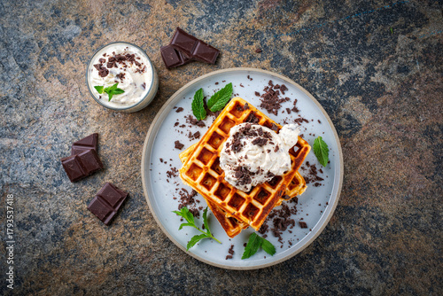 Fresh baked homemade Belgian  Brussels waffles with mascarpone cream fresh and dark chocolate topping served as top view on a design plate