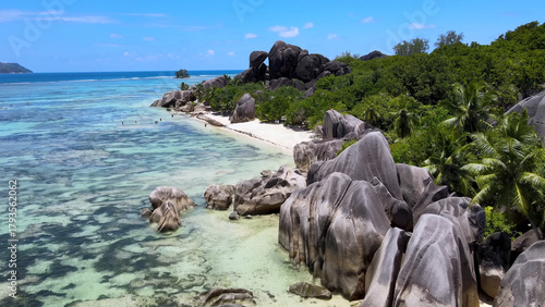 Luxury resort photo of Seychelles tropical paradise islands in Indian Ocean with palm trees, sandy beach, stones. Beautiful photography, coral reef, azure ocean, 
sky with clouds on horizon.  