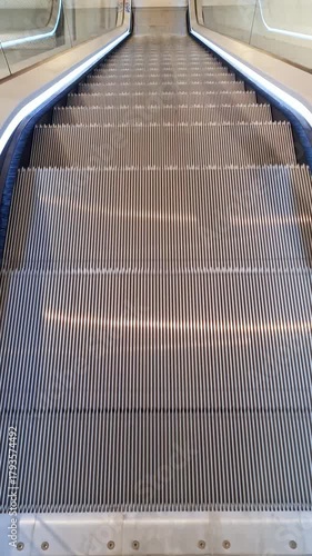 Empty modern escalator moving down in a public building