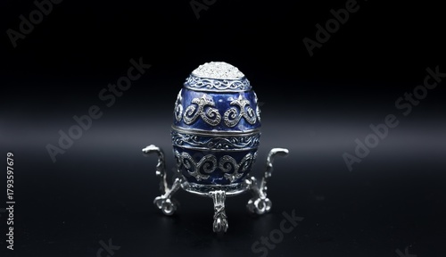 Ornate Blue and Silver Decorative Egg on Stand on Dark Background