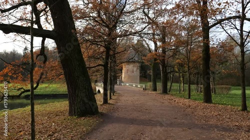 POV walking along branching oak tree alley to the Pil-tower in the Pavlovsk Landscape Park on an autumn day, suburb of St. Petersburg, Russia