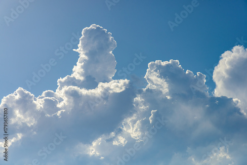 Cumulus white clouds bofies towering in clear blue sky background
