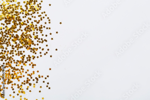 Golden star shape confetti on color background, top view