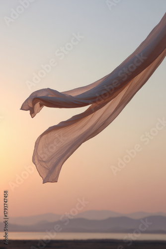delicate fabric sways gracefully in gentle breeze illuminated by warm glow of sunset