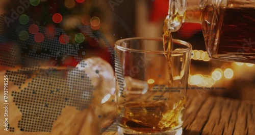 Decanter tilting pouring, tumbler filling with amber liquid swirling settling showing dotted globe