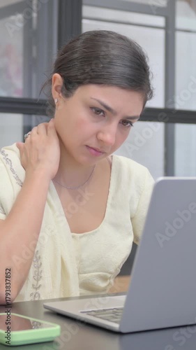 Indian Woman with Neck Pain Working on Laptop, vertical video