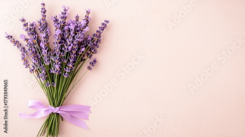 Freshly Cut Lavender Bouquet with Purple Flowers Tied with a Bow Against a Soft Beige Background