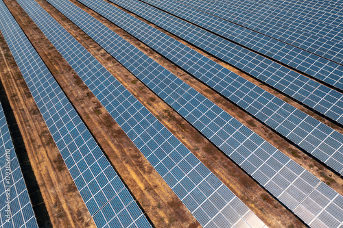 Aerial drone view of rows of solar panels installed on ground creating renewable energy at modern solar power farm showcasing clean sustainable electricity production