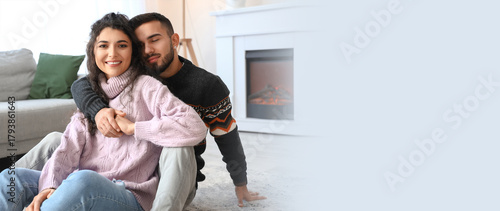 Happy young couple wearing warm sweaters at home