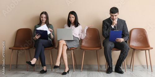 Schilderij op canvas Young applicants waiting for job interview near beige wall