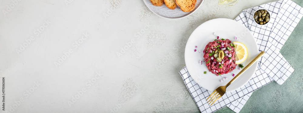 Obraz premium Plate with tasty beef tartare on light background