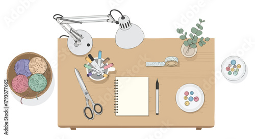 Creative workspace featuring colorful yarn, stationery, and decorative elements atop a wooden desk under a silver lamp