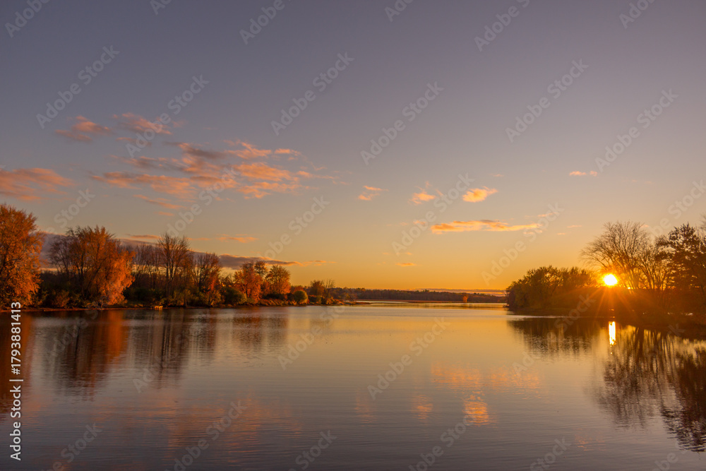 Obraz premium Colorful fall leaves with beatiful sunset on the lake