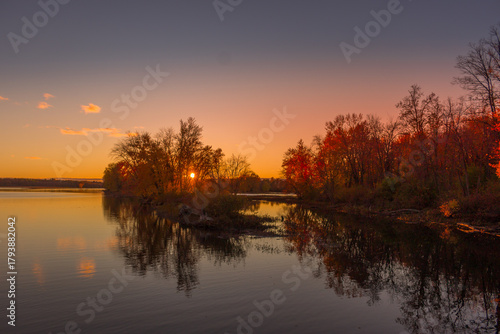 Colorful fall leaves with beatiful sunset on the lake