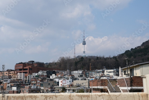 Namsan tower or N Seoul tower rising high up on the mountain behind old packed houses in Seoul, Korea. Landmark tower.