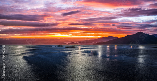 Foto Empty wet asphalt road and beautiful mountain range with dramatic sky clouds at