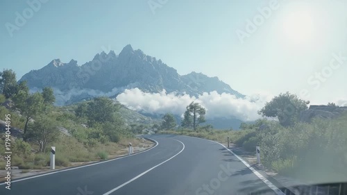 Road leading to mountain peaks with clouds