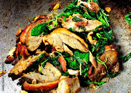 Cooking stir-fried roasted duck with basil, Thai famous food.